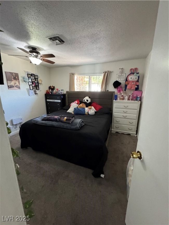 Carpeted bedroom with a textured ceiling and a ceiling fan | Image 7