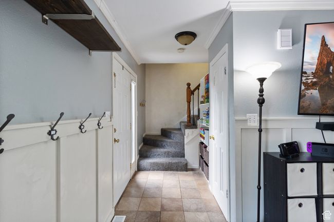 Stairway with crown molding, wainscoting, carpet flooring, and a decorative wall | Image 17