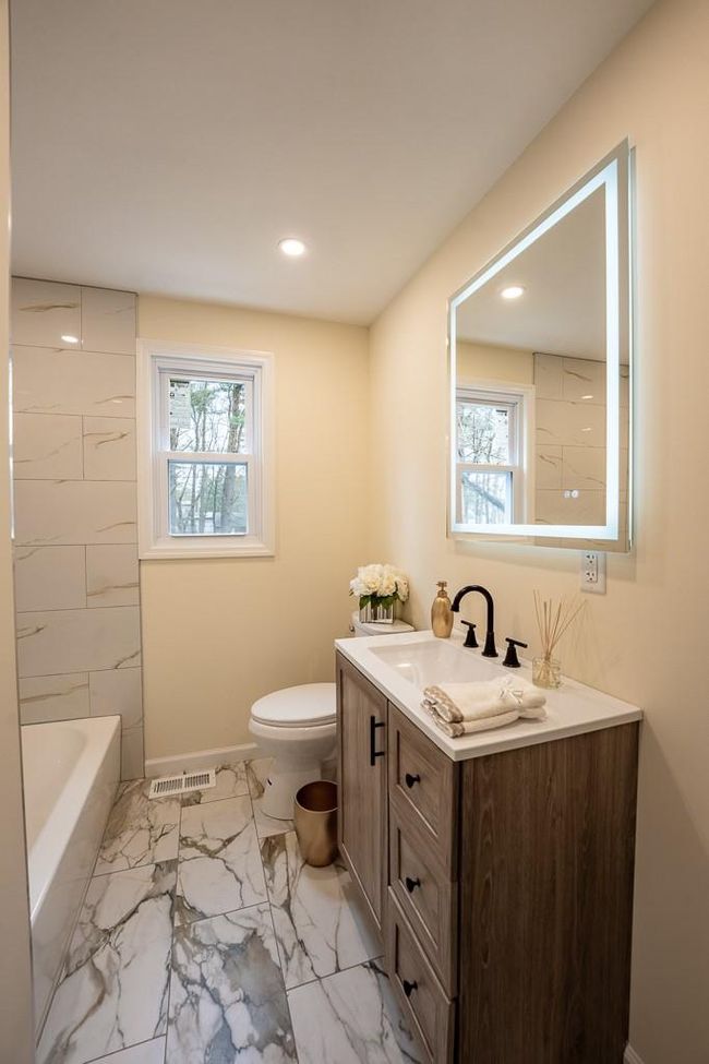 Bathroom with vanity, baseboards, a tub, toilet, and visible vents | Image 18