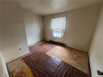 Unfurnished room with hardwood / wood-style flooring and a baseboard heating unit | Image 3