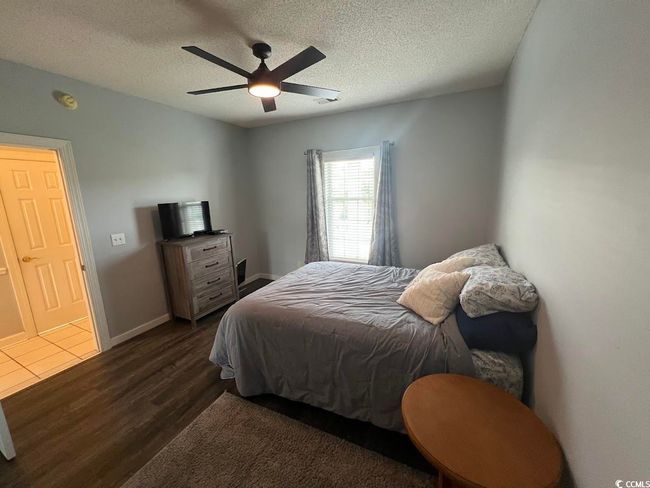 Bedroom with dark wood-style flooring, a textured ceiling, and a ceiling fan | Image 8