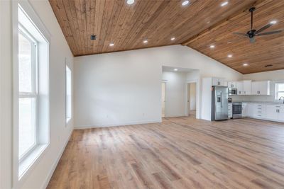 Kitchen featuring appliances with stainless steel finishes, white cabinets, a healthy amount of sunlight, and vaulted ceiling with beams | Image 3