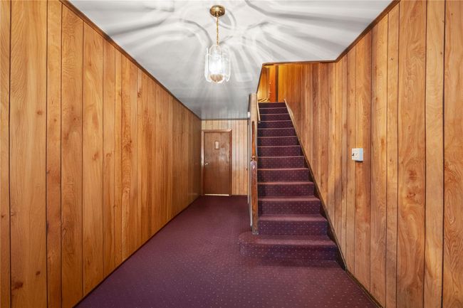 Staircase with wooden walls and carpet flooring | Image 23