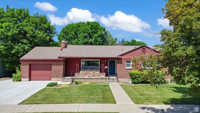 Ranch-style house with a garage, a chimney, driveway, brick siding, and a front lawn | Image 38