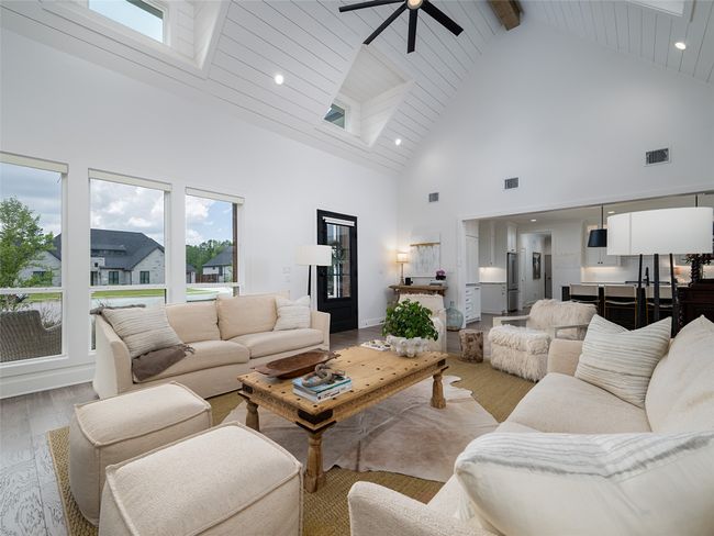 Living room with high vaulted ceiling, light wood finished floors, a ceiling fan, healthy amount of natural light, and beam ceiling | Image 8