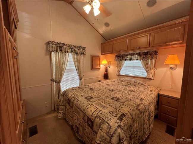 Carpeted bedroom featuring lofted ceiling and ceiling fan | Image 8