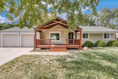 View of front facade with a front yard, a garage, and a deck | Image 1