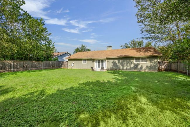 Rear view of property with a fenced backyard and a chimney | Image 29