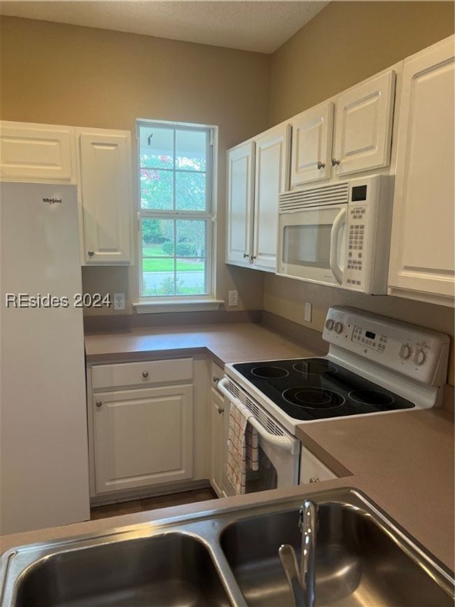 Kitchen featuring white cabinets, fridge, range, and a textured ceiling | Image 15