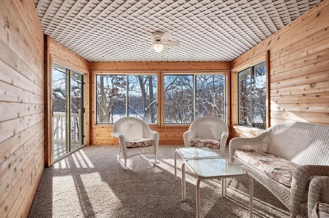 Restore your connection to nature (without the bugs) in this three season porch. You have direct access to the deck and lovely views of the lake. This is a great space for entertaining and relaxing. | Image 15