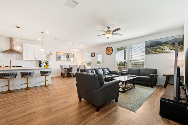 Living room with a ceiling fan, light wood-style flooring, and recessed lighting | Image 4