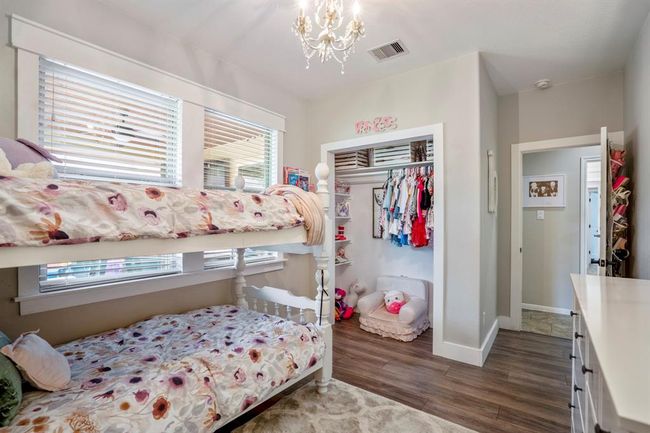 This view of the bedroom highlights the custom closet space, thoughtfully built with shelving that blends seamlessly into the room’s living area. Just across the hall, the bathroom entrance adds easy convenience, making this space both functional and inviting. | Image 26