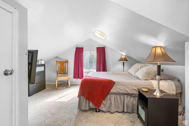 Bedroom with carpet floors and vaulted ceiling | Image 9