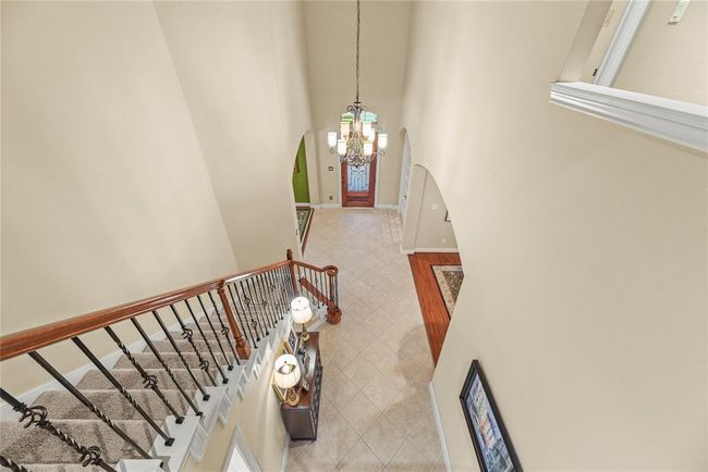 View of front door and foyer from upstairs mezzanine. | Image 23