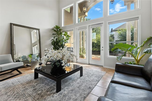 Living area with tile patterned flooring and a towering ceiling | Image 7
