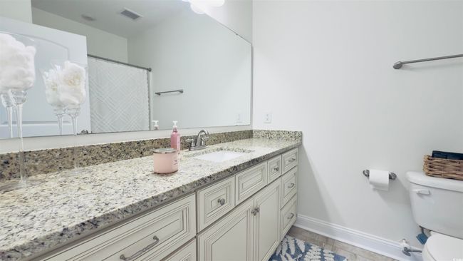 Bathroom featuring vanity and curtained shower | Image 28