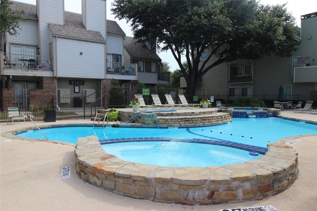 View of swimming pool featuring a patio, fence, and a pool with connected hot tub | Image 17