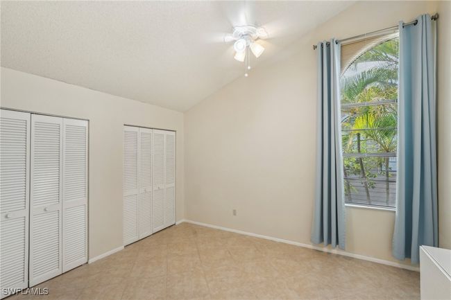 Unfurnished bedroom with multiple closets, multiple windows, lofted ceiling, and a ceiling fan | Image 26