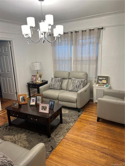 Living room with hardwood / wood-style floors and a chandelier | Image 2