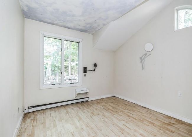 Unfurnished room with light hardwood / wood-style flooring, plenty of natural light, and a baseboard heating unit | Image 15