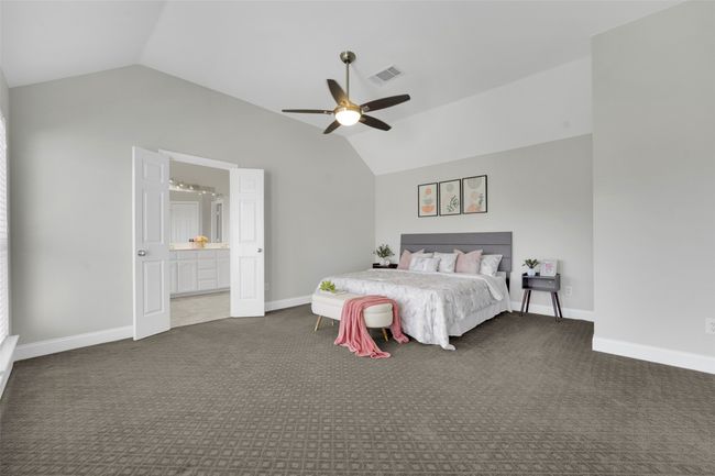 Carpeted bedroom with vaulted ceiling, ceiling fan, and ensuite bathroom | Image 27