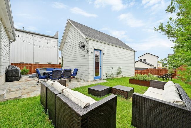 Back of house featuring outdoor lounge area, a patio, a fenced backyard, an outdoor structure, and a garden | Image 24