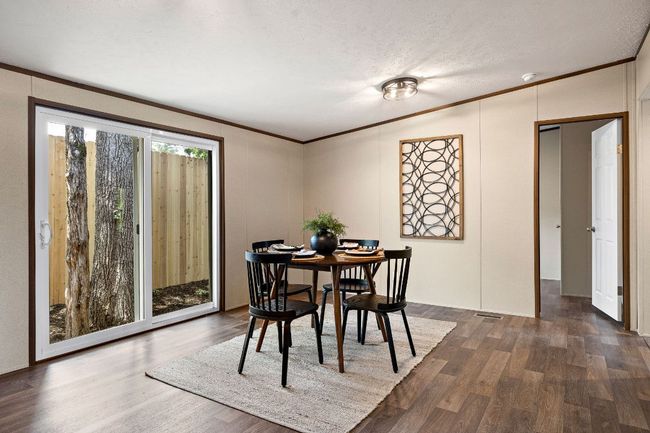 Dining room featuring dark wood-style flooring, crown molding, visible vents, and a decorative wall | Image 20