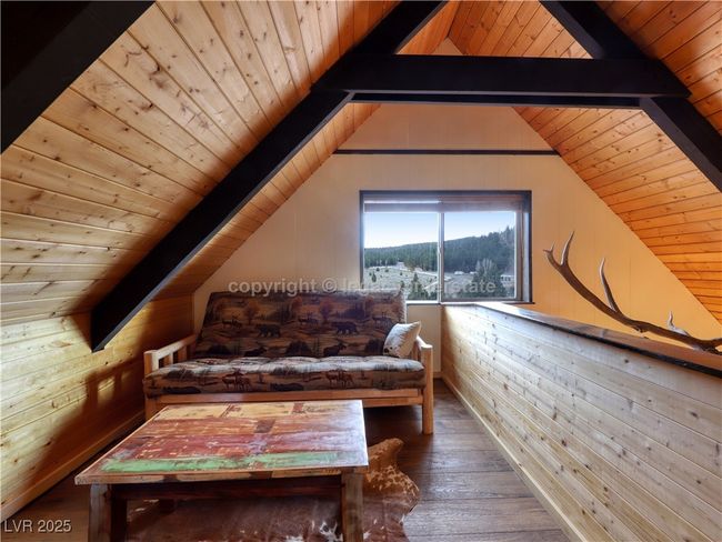 Living area featuring wooden walls, lofted ceiling with beams, wood ceiling, and hardwood / wood-style floors | Image 23