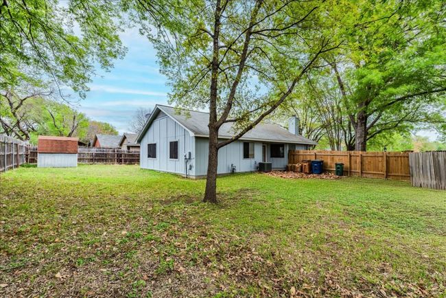 Back of property with a fenced backyard, a storage unit, an outdoor structure, and board and batten siding | Image 24