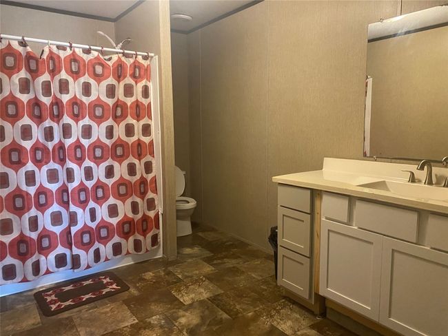 Bathroom with stone tile flooring, vanity, and shower / tub combo | Image 8