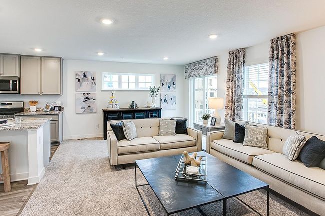 View of the large family room. Model picture shown. Colors and finishes may vary. Subject address is an interior unit. Exterior unit photos shown. | Image 7
