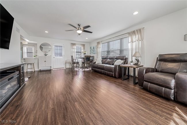 Living area with dark wood finished floors, recessed lighting, and a ceiling fan | Image 19
