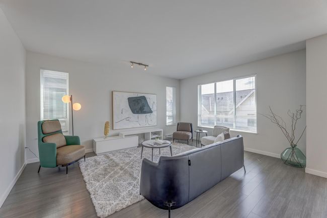 Living area featuring wood finished floors, healthy amount of natural light, and track lighting | Image 7