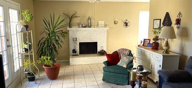 8834 Living room with plenty of natural light, a brick fireplace, and light tile floors | Image 6