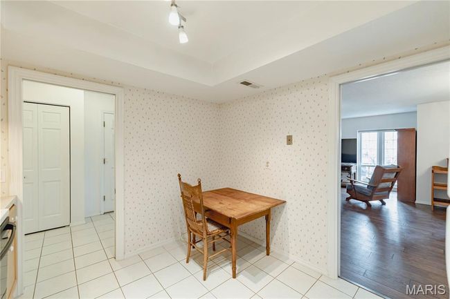 Dining area with wallpapered walls and light tile patterned floors | Image 27