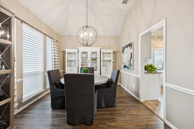 Dining area with a chandelier, wood-style floors, and vaulted ceiling | Image 5