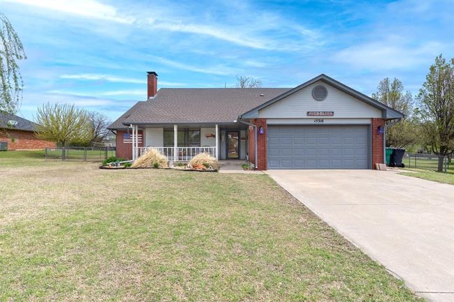 Ranch-style home with brick siding, concrete driveway, a garage, and a front lawn | Image 5