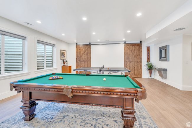 Recreation room with a barn door, wood finished floors, recessed lighting, and pool table | Image 60