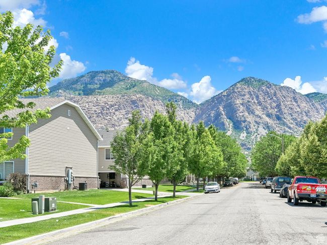 View of asphalt street with sidewalks, a mountain view, curbs, and a residential view | Image 25