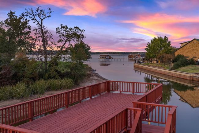 Deck at dusk featuring a water view | Image 34