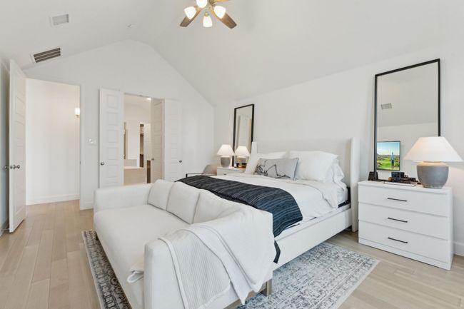 Bedroom with light wood finished floors, vaulted ceiling, a ceiling fan, and baseboards | Image 17
