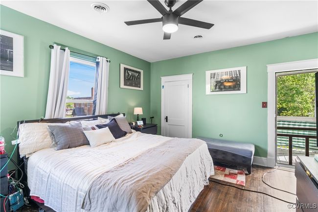 Bedroom with wood finished floors, access to exterior, multiple windows, and visible vents | Image 33