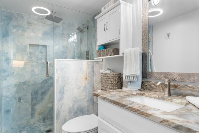 Full bathroom with a shower stall, vanity, and toilet | Image 17