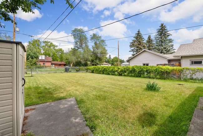 Fully fenced backyard with storage shed | Image 19