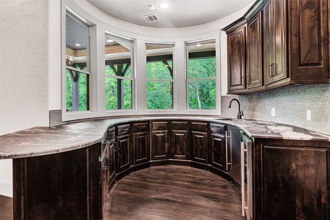 You'll think you're at a high-end nightclub when you step into the wet bar with ice maker and 45 bottle wine fridge! Just be careful mixing drinks for family and friends because you might be tempted to stare out the window at the peaceful trees instead. | Image 20