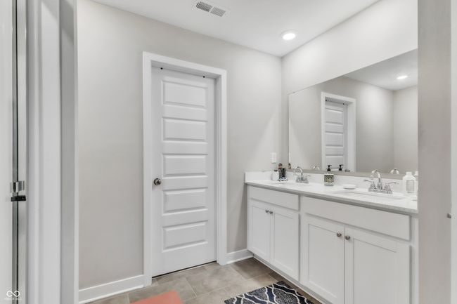 bathroom featuring tile patterned floors, double vanity, visible vents, and a sink | Image 21