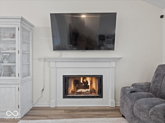 details featuring a lit gas log fireplace & mantle | Image 7