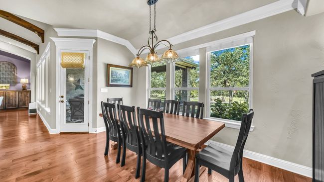 Dining space with wood finished floors, a chandelier, and lofted ceiling | Image 23