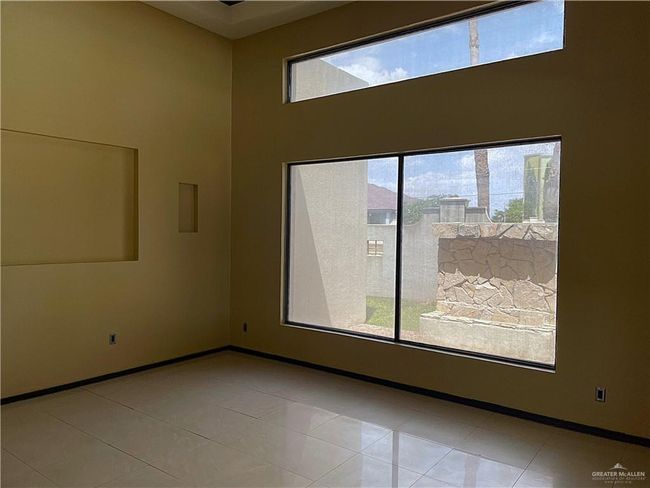 Unfurnished room featuring plenty of natural light, a high ceiling, baseboards, and tile patterned floors | Image 27
