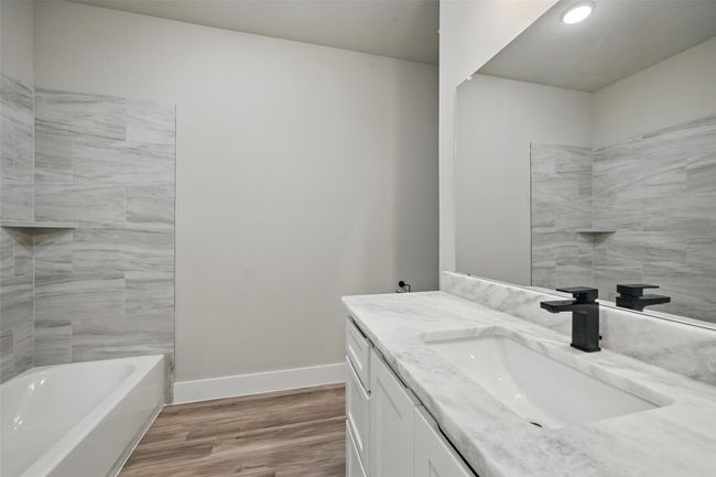 Full bath with baseboards, wood finished floors, vanity, and a bathtub | Image 11
